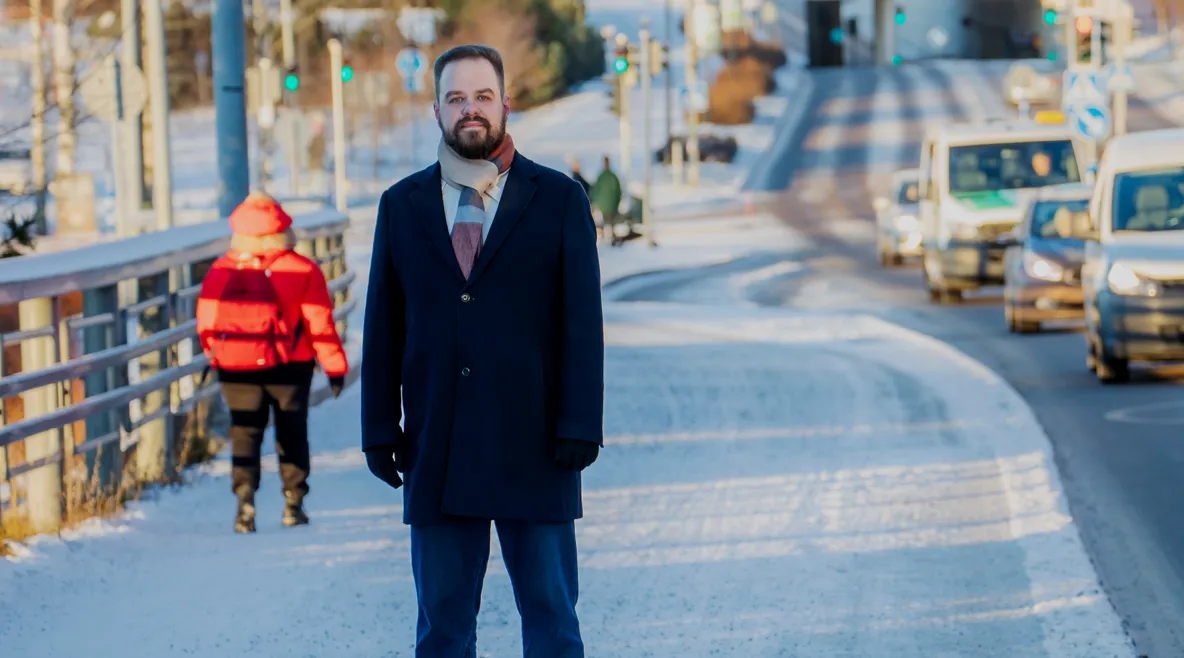 Ensihoitaja Aapo Liukko talvisessa kaupunkilimjöössä vilkkaan autotien vieressä.