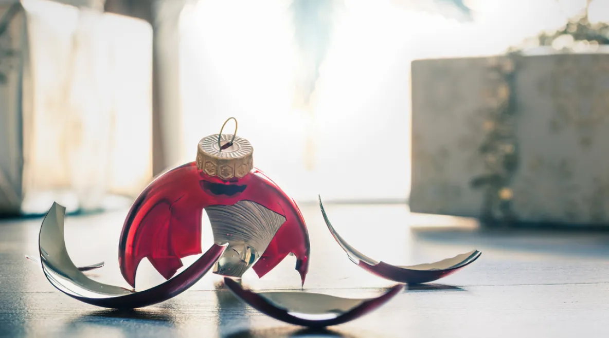 Rikkinäinen joulupallo lattialla.