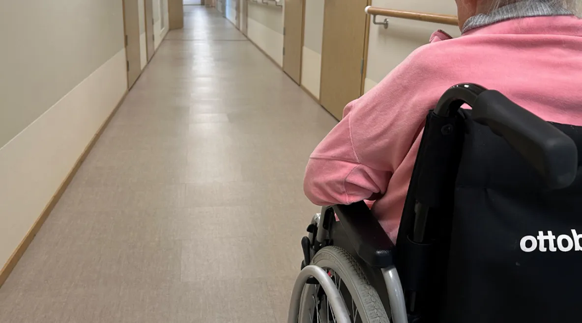 Vanhusasiavaltuutetun mukaan esimerkiksi ympärivuorokautisen hoidon ja kotihoidon kriteerejä on tiukennettu kohtuuttomasti. Vanhus ymoärivuorokautisessa hoidossa pyörätuolissa käytävällä.