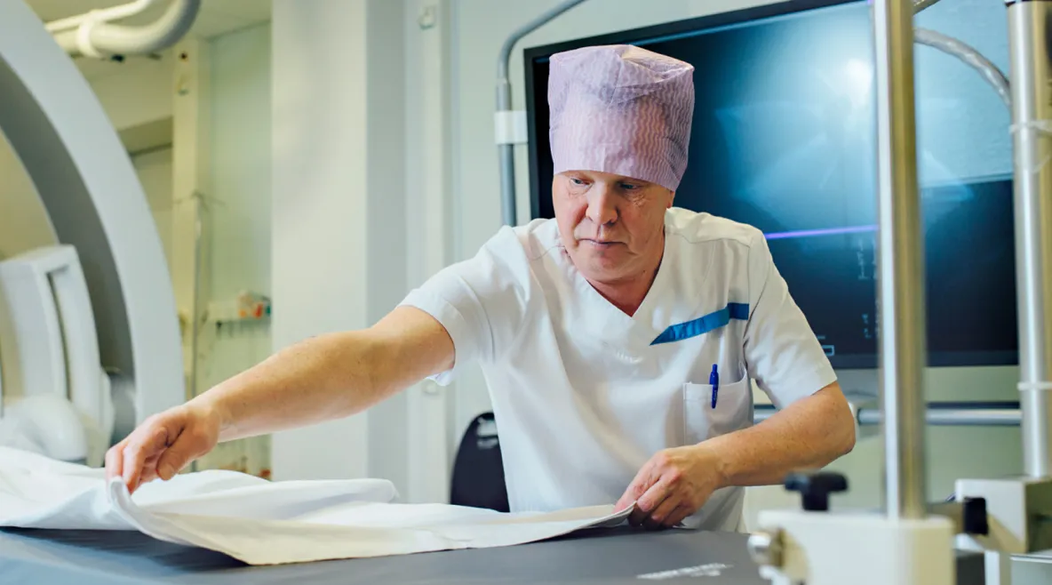 Laitoshuoltaja ilkka Hyvönen huolehtimassa hoitohuoneen puhtaudesta.