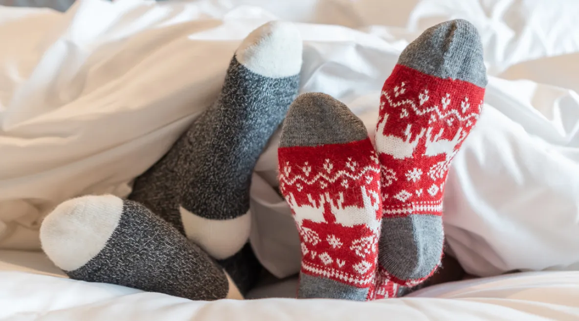 Pariskunnan villasukat pilkottavat peiton alta.