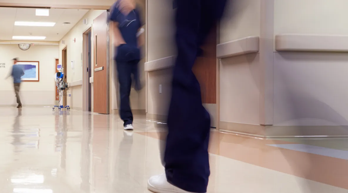 Hoitajia kävelemässä ripeästi sairaalan käytävällä.