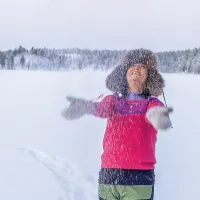 Indira Niittyvuopio heittää lunta ilmaan karvahattu päässään.