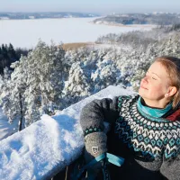 Vivi Aaltonen nautiskelee lumisessa maisemassa näköalapaikalla.