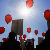 Tehyläinen mielenosoitus, iso väkijoukko auringossa, punaiset ilmapallot.