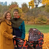 Saana Adam-Kitinoja ja vaimo Rebecca lastenrattaiden kanssa puistossa.
