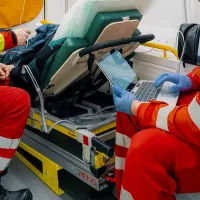 Ensihoitaja kirjaa ambulanssissa tietoja.