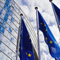 EU-liput lipputangossa korkean rakennuksen edustalla.