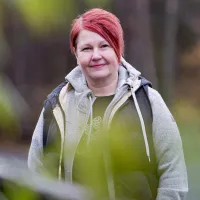 Lastenhoitaja Jaana Olsen puolilähikuvassa ulkona. 