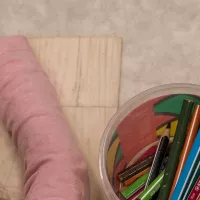Lapsi värittää kuvaa puisilla värikynillä. 