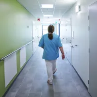 Hoitaja kävelee kiireesti palvelutalon käytävällä.