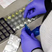 Hoitaja jakaa lääkkeitä dosettiin.