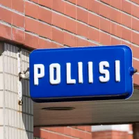 Poliisiaseman kyltti talon seinässä. 