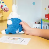 Terveydenhoitaja leikittää lasta neuvolassa.