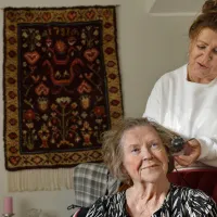 Katariina Salminen laittaa äitinsä hiuksia.