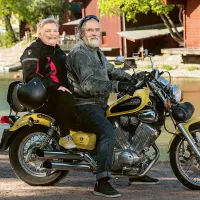 Outi ja Sami Helasterä moottoripyörän selässä.