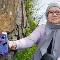 Tiina De Stele ja kivi, joka on maalattu hoitajalta näyttäväksi Muumien mörköhahmoksi.