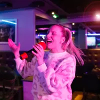 Emmi Bogdanoff laulaa karaokebaarissa.