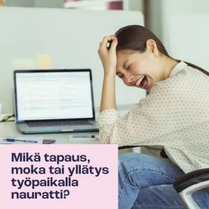 Nainen nauraa kannettavan tietokoneen äärellä.
