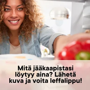 Hymyilevä nainen kurkottaa ottamaan paprikan jääkaapista.