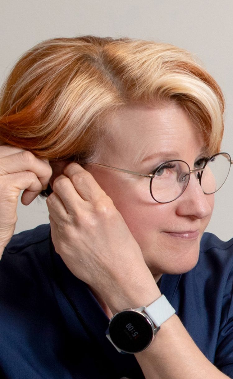 Sairaanhoitaja Leila Hällfors laittaa korvaansa kuulolaitetta.