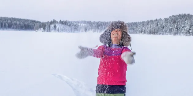 Indira Niittyvuopio heittää lunta ilmaan karvahattu päässään.