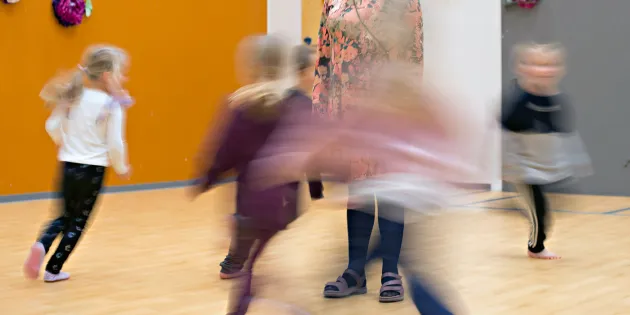 Lapsia juoksemassa päiväkodin jumppasalissa. 
