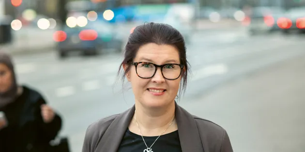 Tanja Simola seisoo jalkakäytävällä, taustalla katuvilinää.