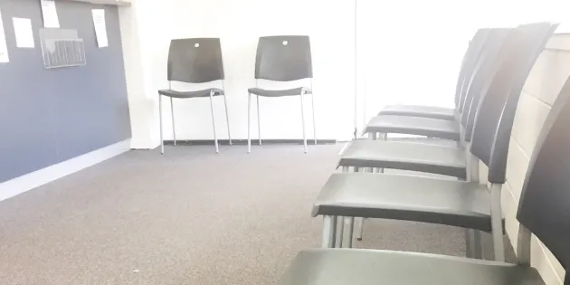 Sairaalan tyhjä odotustila. Tuoleja rivissä seinustalla. Kolme uutta hyvinvointialuetta valtion arviointimenettelyyn