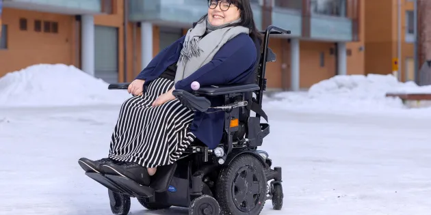 Aino Ikävalko pyörätuolissa kotinsa edustalla.