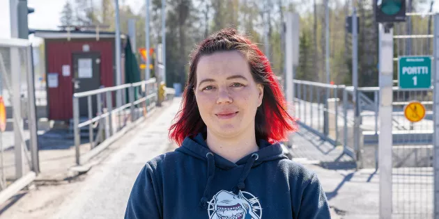 Jenni Korpinen tehtaan portilla.