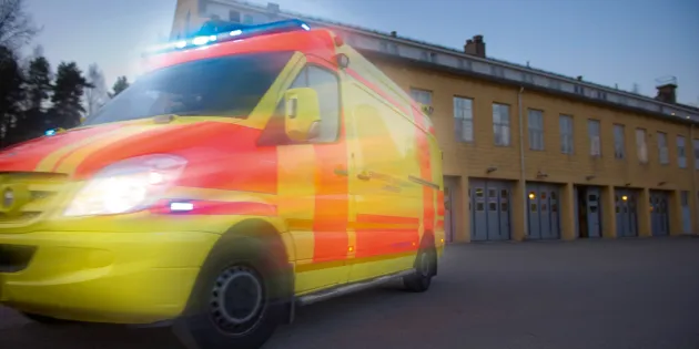 Ambulanssi ajaa kameran ohi, kuva epäselvä. 