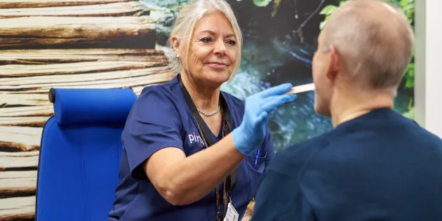Työfysioterapeutti Kirsi Tervakangas tunnustelee asiakkaan leukaperiä.