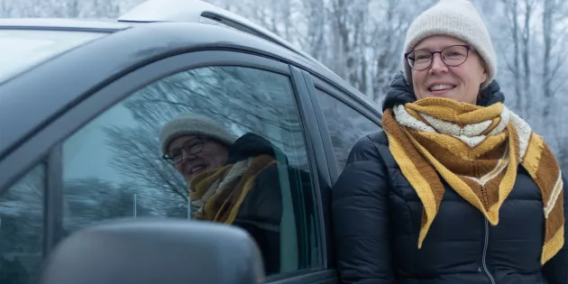 Päivi Laine auton vieressä.