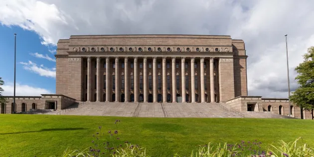 Eduskuntatalo kuvatutna ulkoapäin keväisessä maisemassa.