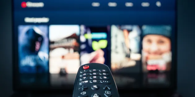 Kaukosäädin osoittaa televisioruudulla näkyvää suoratoistopalvelua.