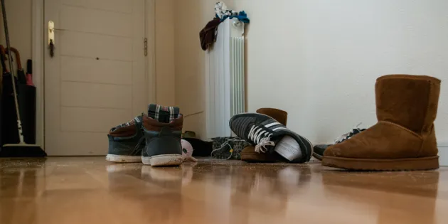 Kenkiä sikin sokin eteisen lattialla.