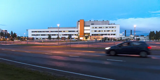 Seinäjoen keskussairaala ulkoapäin kuvattuna. Auto ajamassa rakennuksen ohi.