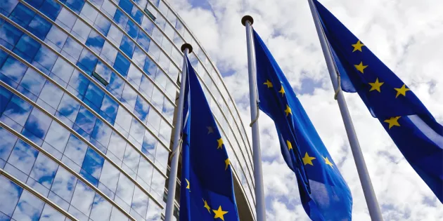EU-liput lipputangossa korkean rakennuksen edustalla.