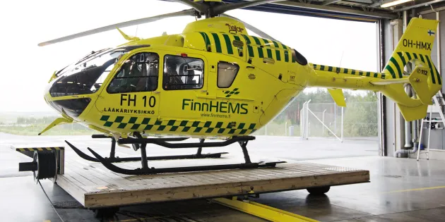 FinnHEMS helikopteri siiretään ulos hallista liikkuvalla lavetilla. 