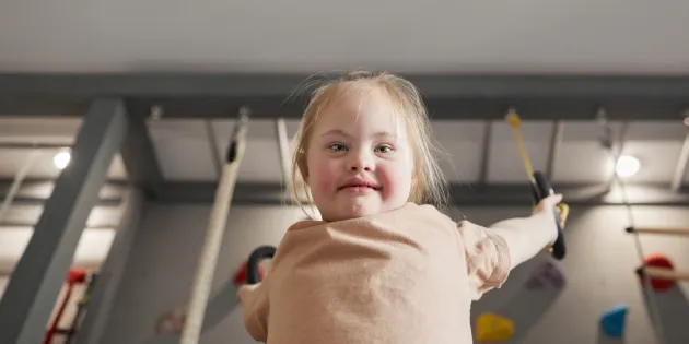 Kehitysvammaliiton ja Autismiliiton toiminta on vaarassa loppua kokonaan hallituksen sotejärjestöjen leikkauksien vuoksi. Nuori kehitysvammainen tyttö leikkii voimistelurenkaissa.