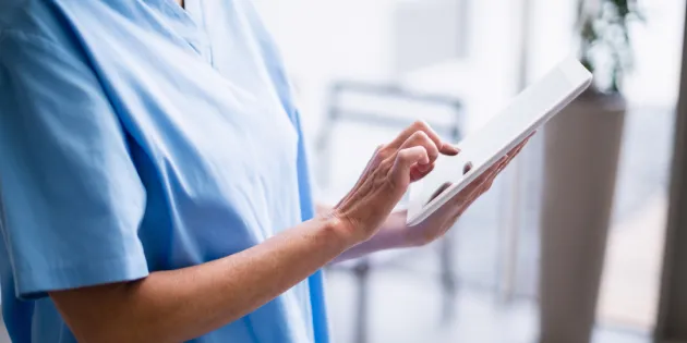 15 sairaanhoitajaa täydensi tutkintoaan suomalaisia osaamisvaatimuksia vastaavaksi Hämeen ammattikorkeakoulussa osana valtakunnallista SAILA-hanketta. Sairaanhoitaja katsoo tabletilta tietoja.