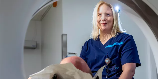 Karoliina Halme tietokonetomografialaitteen äärellä. 