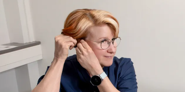 Sairaanhoitaja Leila Hällfors laittaa korvaansa kuulolaitetta.