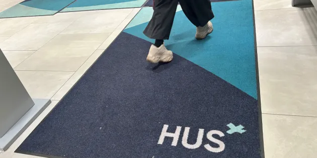 Alle 13-vuotiaiden lasten psykiatriseen hoitoon pääsee Husissa nopeasti. Nuori kävelee sairaalassa maton yli, jossa Husin logo.