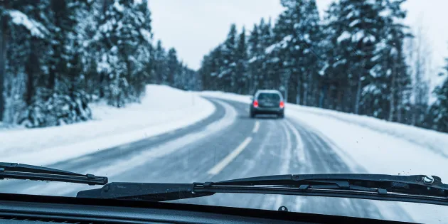 Talvinen maantie, jossa näkyy edellä ajava auto