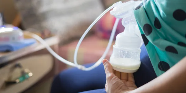 Nainen käyttämässä rintapumppua.