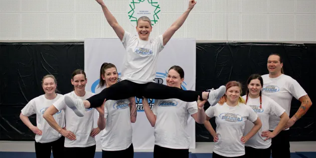 Cheerleadingjoukkue nostaa Raisa Vitikan ilmaan.