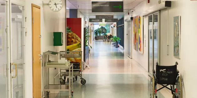 Kuva Länsi-Pohjan sairaalan käytävältä. Ei ihmisiä näkyvissä, tyhjä pyörätuoli kuvan alareunassa.