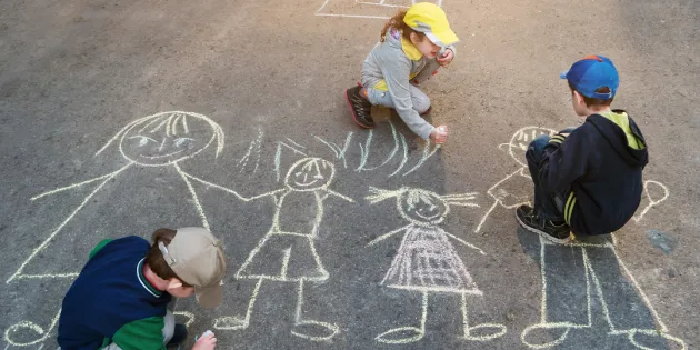 Täysin rokottamattomien lasten osuus on kasvussa. Lapset leikkivät kadulla ja piirtävät katuliiduilla asfalttiin ihmishahmoja.